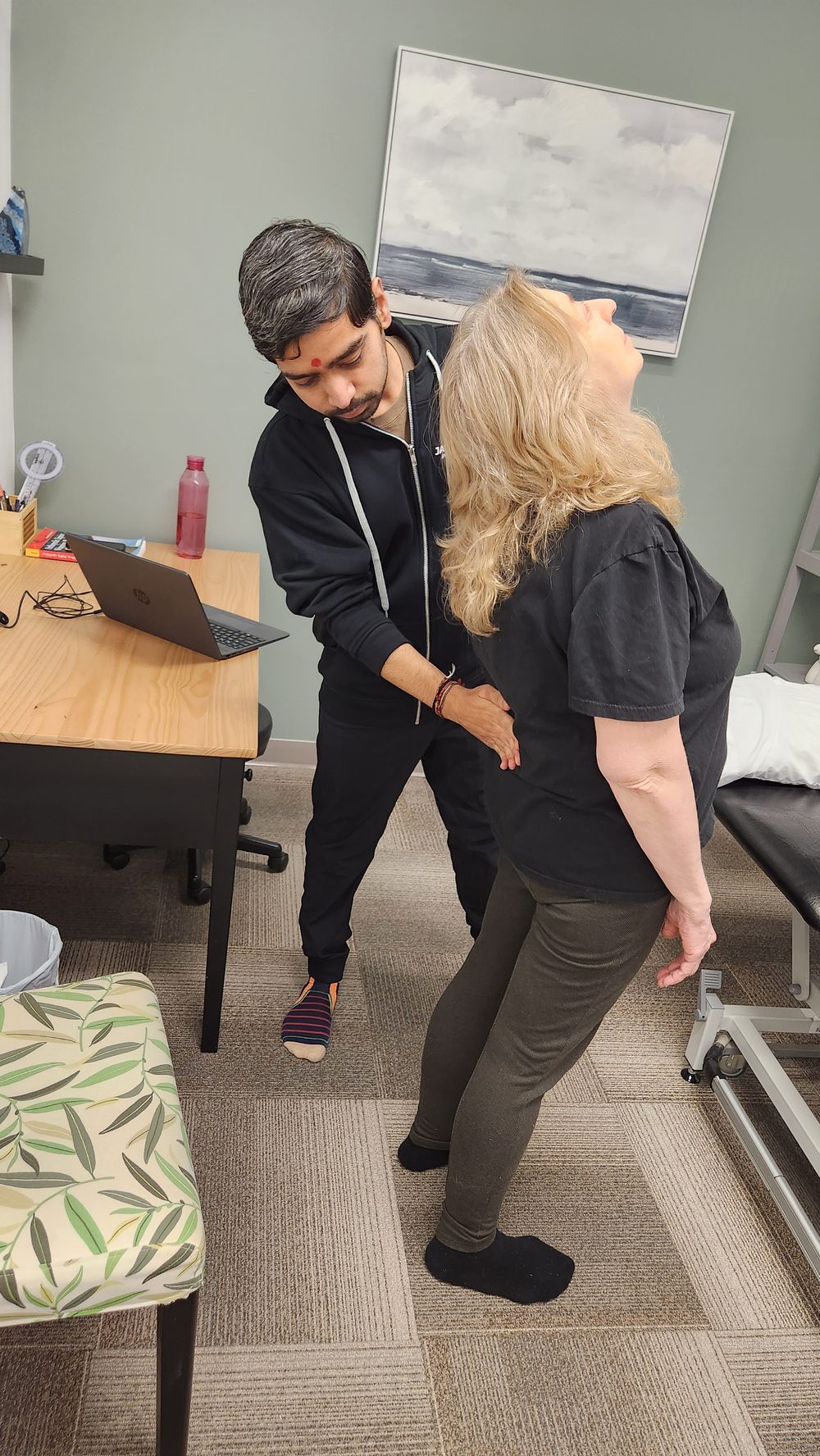 Physiotherapist assessing a patient's lower back movement